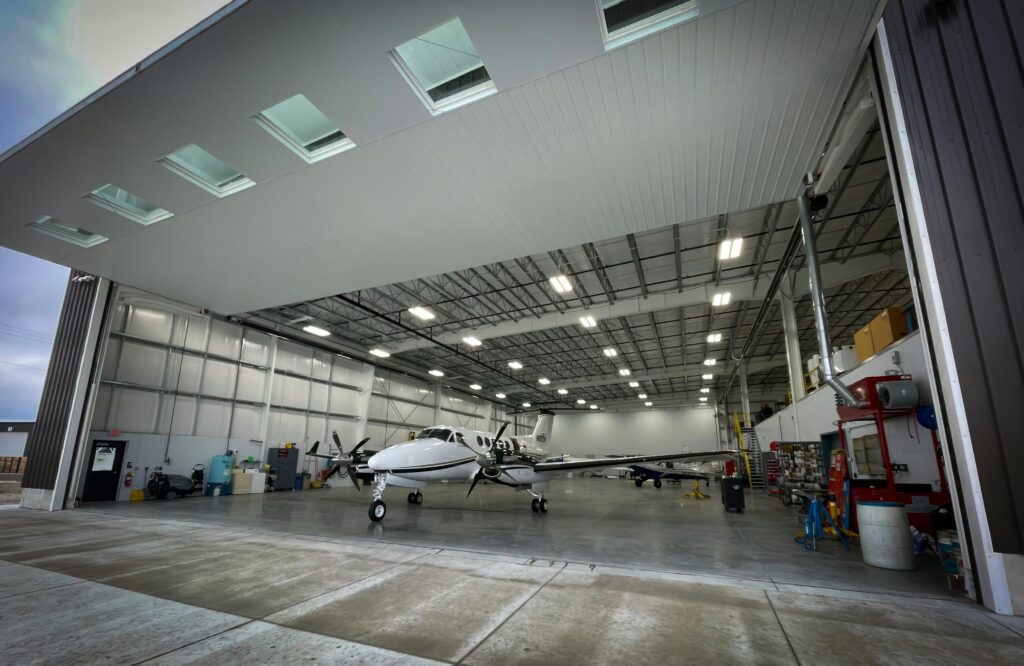 Light aircraft parked inside a spacious modern hangar used for private aviation.