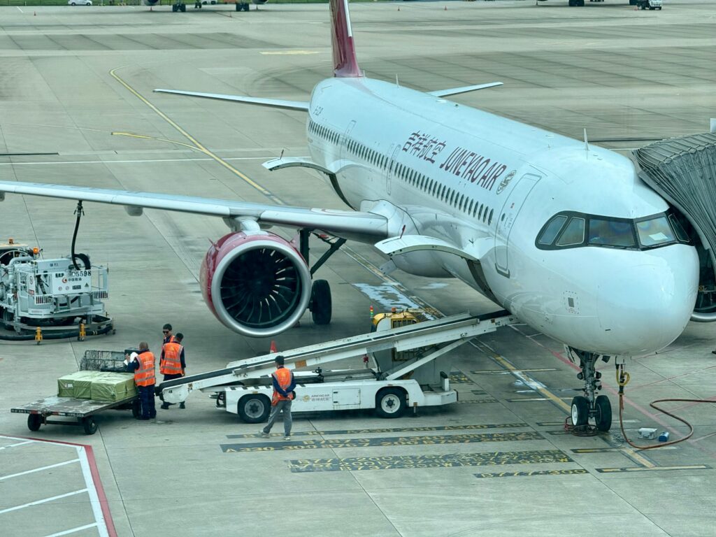 Airplane being loaded with cargo at the airport terminal with ground crew.